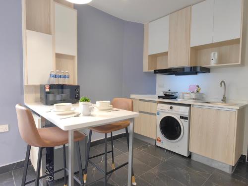 a kitchen with a table and a washing machine at Vetro11 Beside QEH1 by JUNE Homestay in Kota Kinabalu