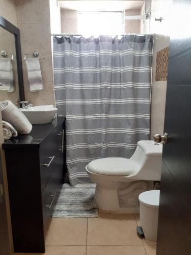 a bathroom with a toilet and a sink and a shower at Dept familiar a pasos de la playa con auto check in in Crucita