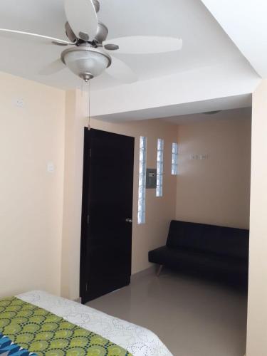 a bedroom with a black door and a black couch at Dept familiar a pasos de la playa con auto check in in Crucita