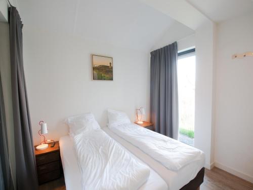 a white bed in a bedroom with a window at Villa Oesterdam Sleeps 8 persons in Tholen