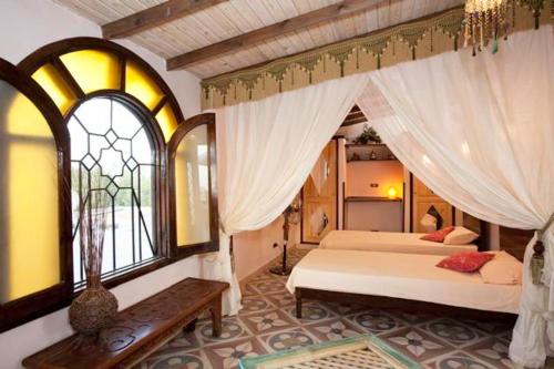 1 dormitorio con 2 camas y ventana en Villa Boheme & Atelier Boheme, en Dahab