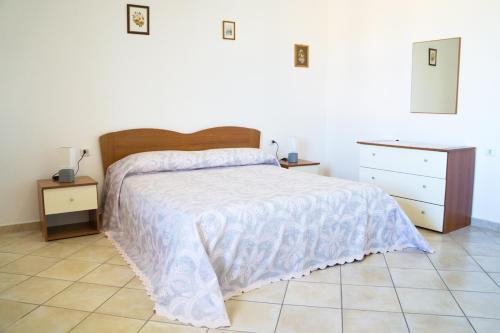 een slaapkamer met een bed met een wit dekbed bij Casa Vacanza da Luisa in San Giovanni Suèrgiu