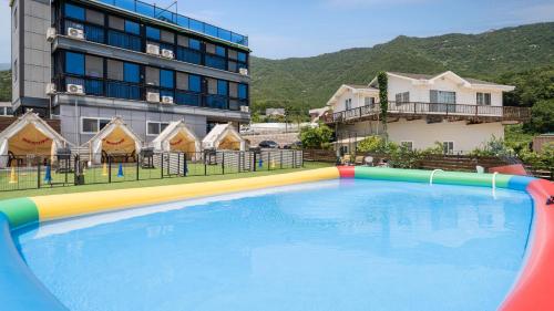 a large swimming pool in front of a building at Namhae Dangdangi Dog Pension Blue in Namhae