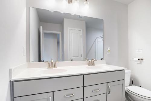 a bathroom with two sinks and a large mirror at New Charming Surburban Retreat 12 mins to Lakepoint in Acworth
