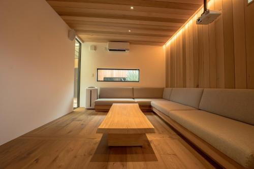a living room with a couch and a coffee table at Tiny Base The Irita-hama in Shimoda