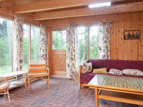 a living room with a purple couch and some windows at 6 person holiday home in Store Fuglede-By Traum in Store Fuglede