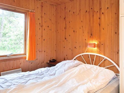 a bed in a wooden room with a window at 6 person holiday home in Store Fuglede-By Traum in Store Fuglede