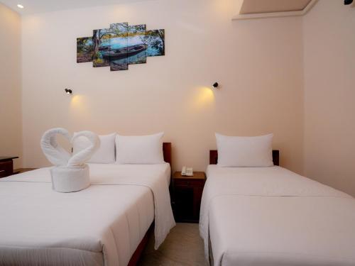 two beds with white sheets with a heart on them at Infenta's Villa in Pandattarippu