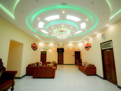 a lobby with couches and a ceiling with a chandelier at Infenta's Villa in Pandattarippu