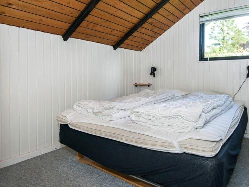 a large bed in a room with a wooden ceiling at Secluded Oasis by Kvie Lake-By Traum in Ansager
