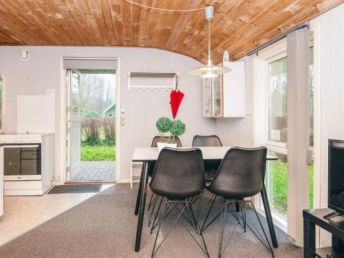 a dining room with a table and black chairs at 4 person holiday home in Grindsted-By Traum in Grindsted