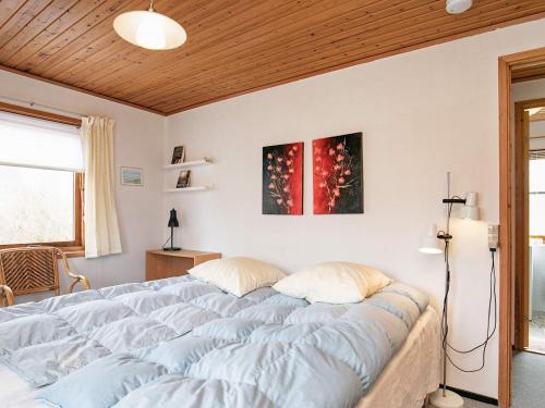 a bedroom with a large bed with blue sheets at 6 person holiday home in Læsø in Læsø