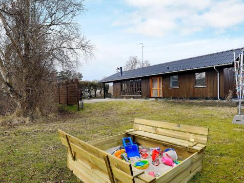 a wooden box filled with toys in a yard at 6 person holiday home in Læsø in Læsø