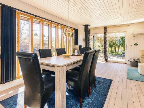 a dining room with a wooden table and black chairs at 6 person holiday home in Læsø in Læsø