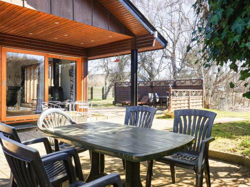 a green table and chairs on a patio at 6 person holiday home in Læsø in Læsø