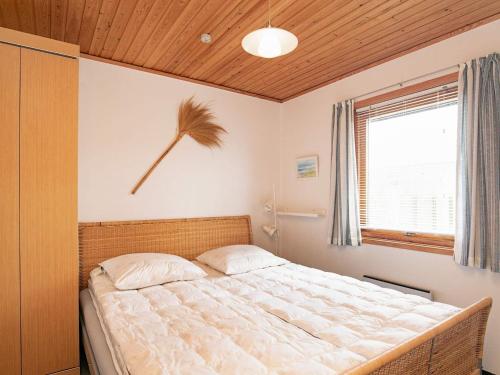 a bedroom with a large bed with a wooden ceiling at 6 person holiday home in Læsø in Læsø