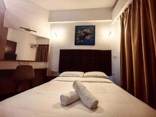 a bedroom with a large white bed and a painting on the wall at Anjung Seri-Amansari Residence Seri Alam 1BR, 1-2 Pax in Masai