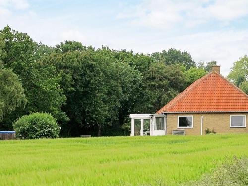 a house with an orange roof in a field at 8 person holiday home in Harpelunde in Harpelunde