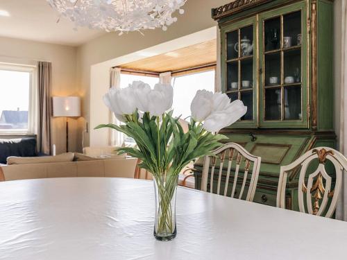 a vase of white flowers sitting on a table at 8 person holiday home in Harpelunde in Harpelunde