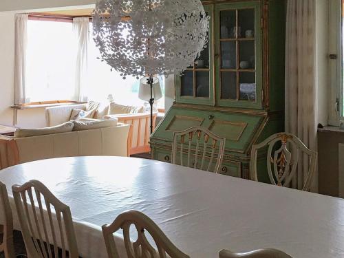 a dining room with a table and chairs and a chandelier at 8 person holiday home in Harpelunde in Harpelunde