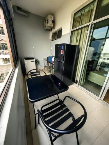a table and chairs on the balcony of a balcony at Anjung Seri-Amansari Residence Seri Alam 1BR, 1-2 Pax in Masai