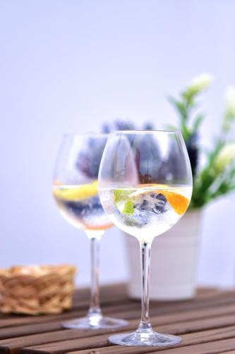 two wine glasses sitting on top of a wooden table at Mercearia D'Alegria Boutique B&B in Peniche
