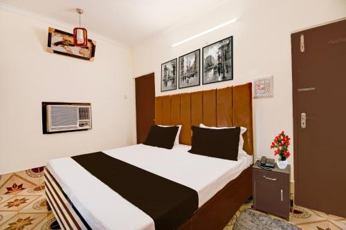 a bedroom with a large bed with a wooden headboard at Hotel O Benia Park Formerly Parv in Varanasi