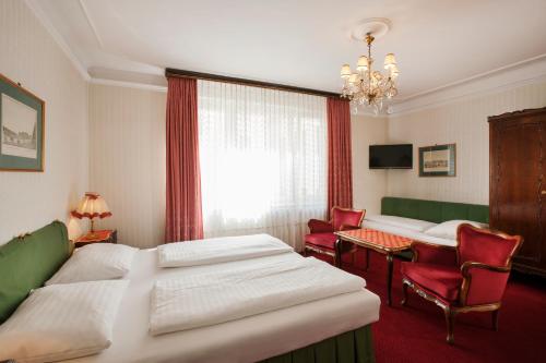 a hotel room with a bed and a table and chairs at Pension Suzanne in Vienna