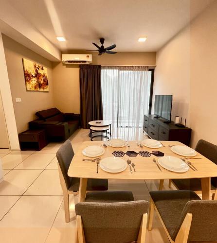 a dining table and chairs in a living room at Sunway Onsen Ipoh by EUcation Home in Tambun