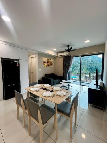 a dining room and living room with a table and chairs at Sunway Onsen Ipoh by EUcation Home in Tambun
