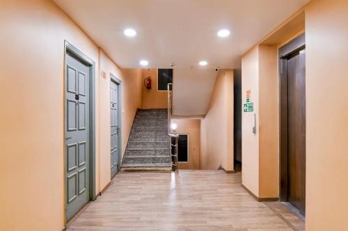 a hallway with stairs and doors in a building at Super Townhouse VIP Road Formerly The Sky in Kolkata