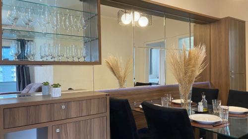 a dining room with a table with chairs and wine glasses at Apartamento próx praia in Balneário Camboriú