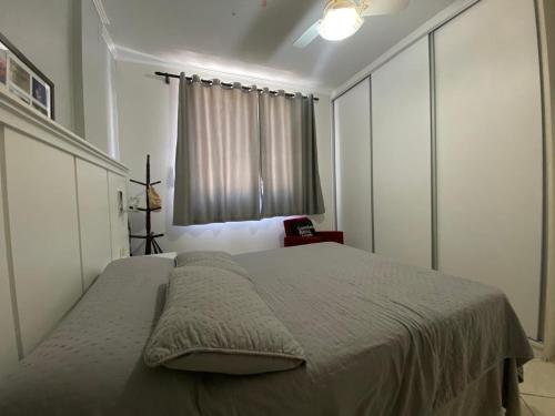a bedroom with a large bed with a window at Apartamento próx praia in Balneário Camboriú
