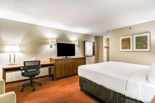 a hotel room with a bed and a desk with a computer at Clarion Hotel BWI Airport Arundel Mills in Hanover