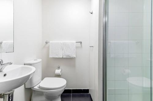 a bathroom with a toilet and a sink and a shower at Quality Apartments North Melbourne in Melbourne