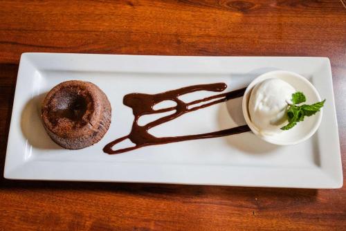 a white plate with a chocolate doughnut and a drink at Clarion Hotel BWI Airport Arundel Mills in Hanover