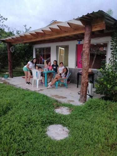 a group of people sitting around a table on a patio at Hotel El Rancho in Istmina
