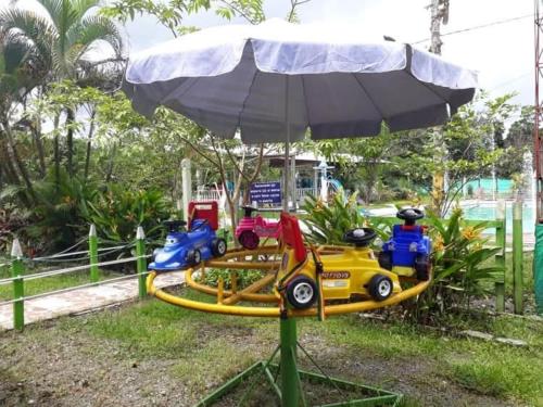 a toy train on a track with an umbrella at Hotel El Rancho in Istmina