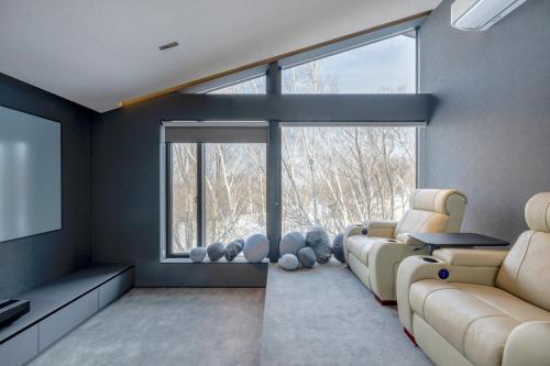 a living room with a couch and a flat screen tv at Meikeikyo Hanazono in Kutchan