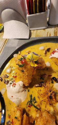 a yellow plate of food with a flower on it at Velvet Sunrise Hotel in Machu Picchu