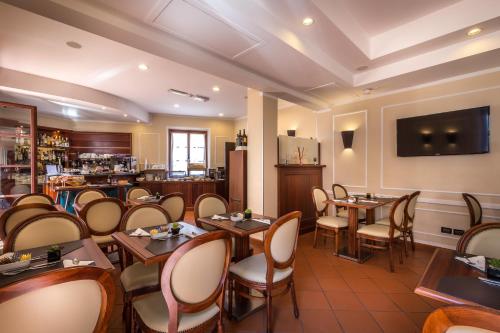 a restaurant with tables and chairs and a bar at Hotel Duomo Firenze in Florence