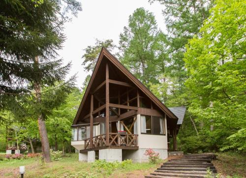 a small house in the middle of a forest at Izumigo AMBIENT Azumino Cottage in Azumino