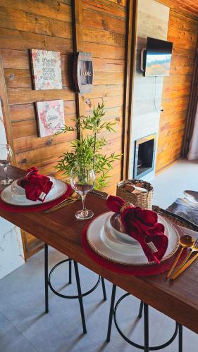 a wooden table with plates and red napkins on it at Chales Vidal in Venda Nova do Imigrante