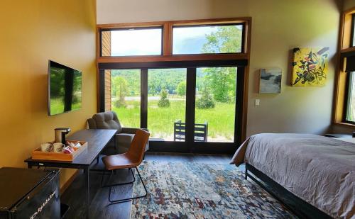 a bedroom with a bed and a desk and a window at Piedmont Grove Lodging in Roseland