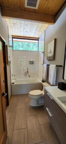 a bathroom with a tub and a toilet and a sink at Piedmont Grove Lodging in Roseland