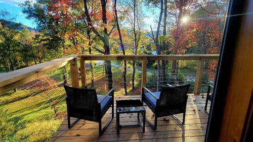 a porch with chairs and a view of the woods at Piedmont Grove Lodging in Roseland