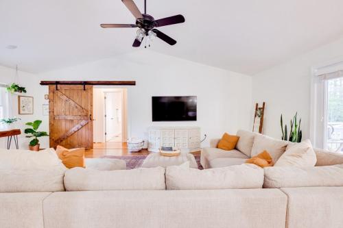 a living room with a couch and a ceiling fan at Red Juniper Retreat 