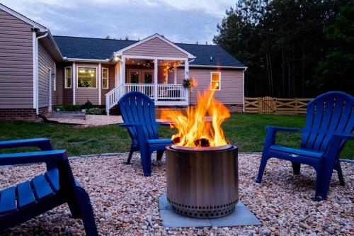 a fire pit in a yard with two chairs at Red Juniper Retreat 