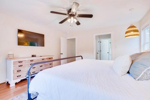 a white bedroom with a bed and a ceiling fan at Red Juniper Retreat 