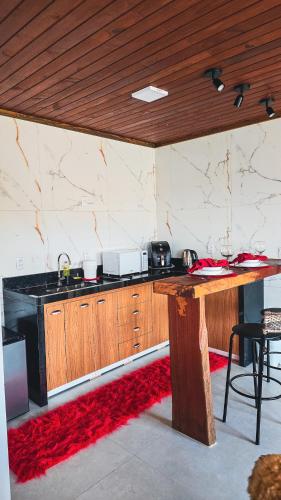 a kitchen with a counter and a table in a room at Chales Vidal in Venda Nova do Imigrante